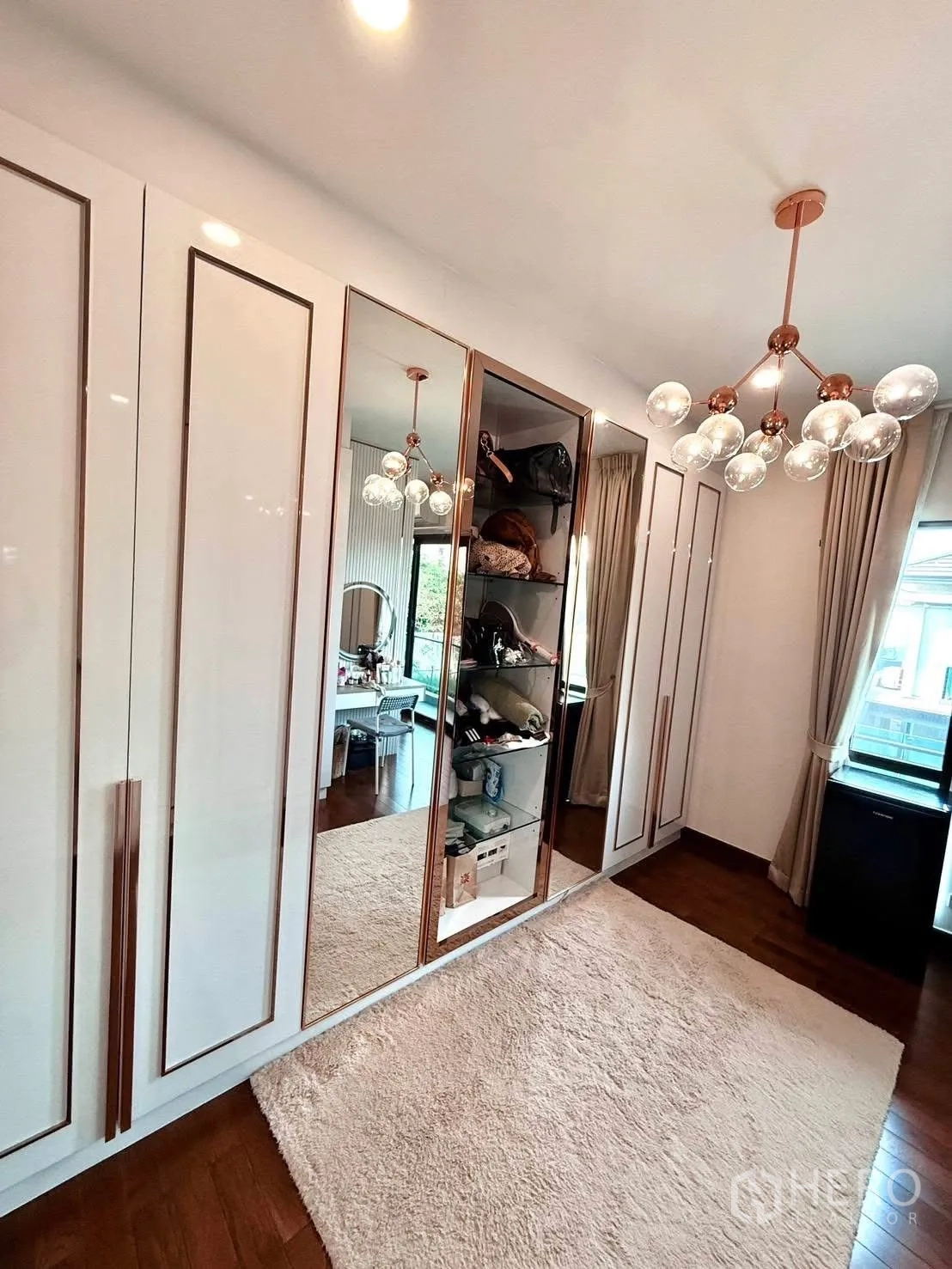 Detached House for rent or sale in Wang Thonglang, Bangkok - Walk-in closet with mirrored wardrobes and chandelier lighting.
