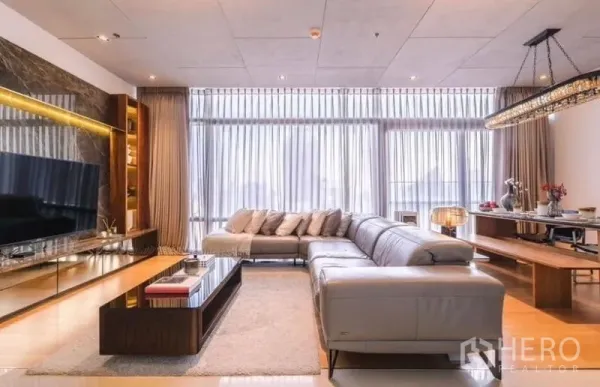 Condominium for rent or sale - Spacious living area with sectional sofa, TV wall and sheer curtains.