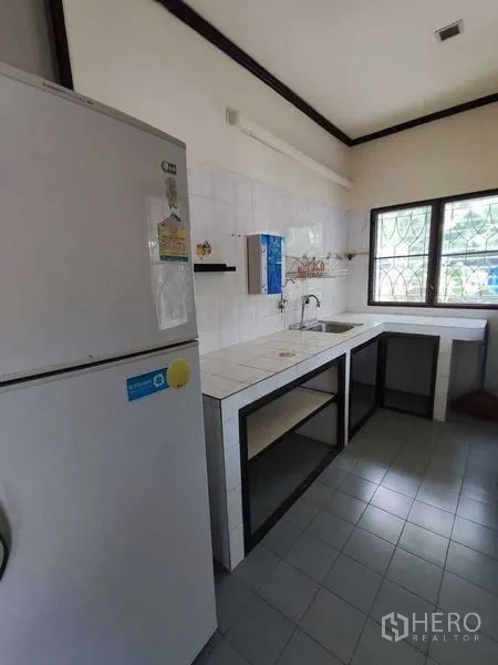 独立式住宅 出租在Khlong Toei, Bangkok - 实用泰式厨房，瓷砖台面、水槽、开放式置物架和冰箱，临窗。