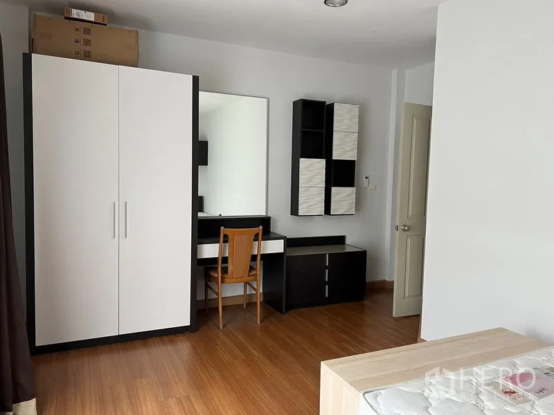 Townhouse for rent in Saphan Sung, Bangkok - Bedroom corner with wardrobe, vanity desk and black-and-white storage units.