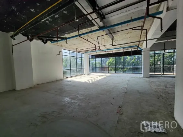 零售空间 出租在Sathon, Bangkok - 采光充足的转角零售空间，落地窗、外露管线与混凝土地面，面向绿景