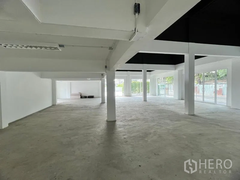Retail Space for rent in Huai Khwang, Bangkok - Open-plan retail shell with white columns, concrete flooring and floor-to-ceiling windows.