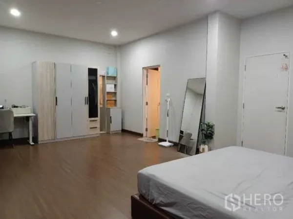 独立式住宅 出租在Mueang Nonthaburi, Nonthaburi - 宽敞卧室，设衣柜、书桌与套内卫生间门，木地板。