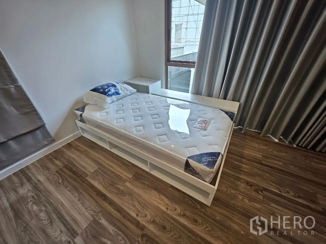 Detached House for rent in Bang Kapi, Bangkok - Single bed frame with new mattress on wood floors beside a window.