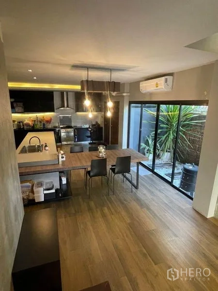 Townhouse for sale in Bang Phli, Samut Prakan - Dining area adjoining kitchen island with pendant lights and access to the small garden.