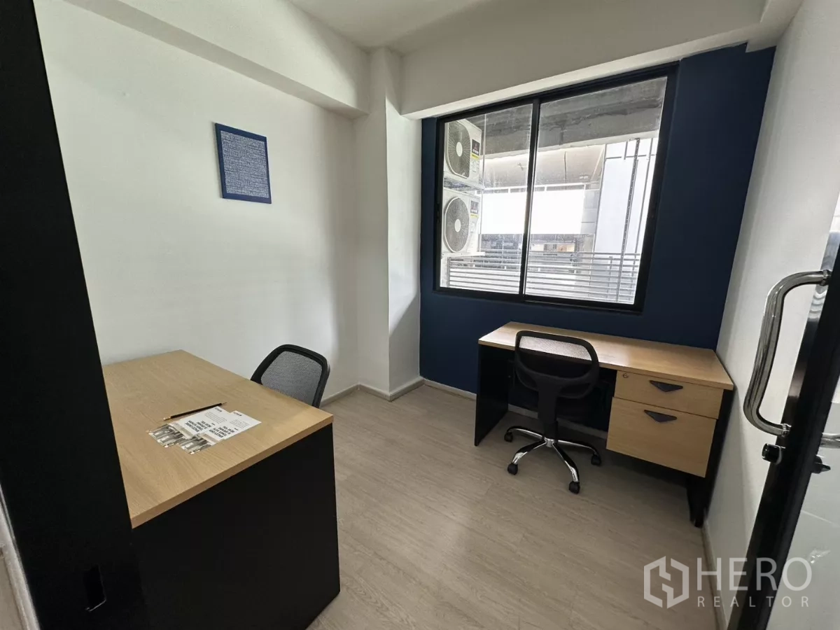 办公空间 出租在Watthana, Bangkok - 紧凑双工位办公室，带大窗，海军蓝特色墙与复合地板。