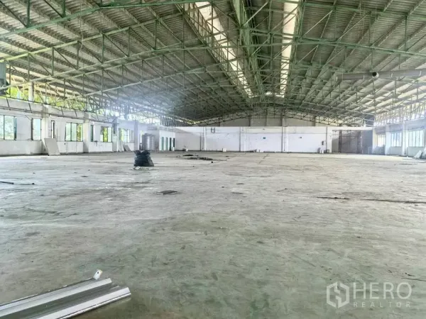 Factory for sale in Bang Phli, Samut Prakan - Expansive warehouse hall with high steel truss roof, clear-span floor and side windows.