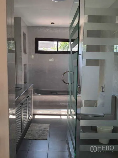 Townhouse for rent in Khlong Toei, Bangkok - Bathroom featuring a glass shower enclosure and bathtub.