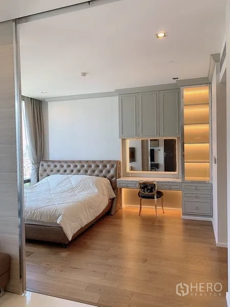 Condominium for sale - Bedroom perspective showing tufted bed and lit built-in desk.