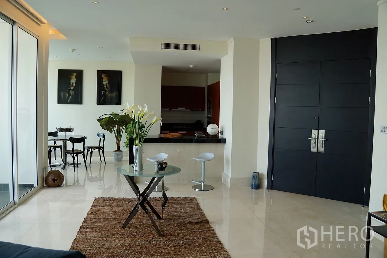 Condominium for rent in Bang Rak, Bangkok - Open-plan living area with glossy floors, breakfast-bar kitchen, and double entry doors in a modern Bangkok condo.