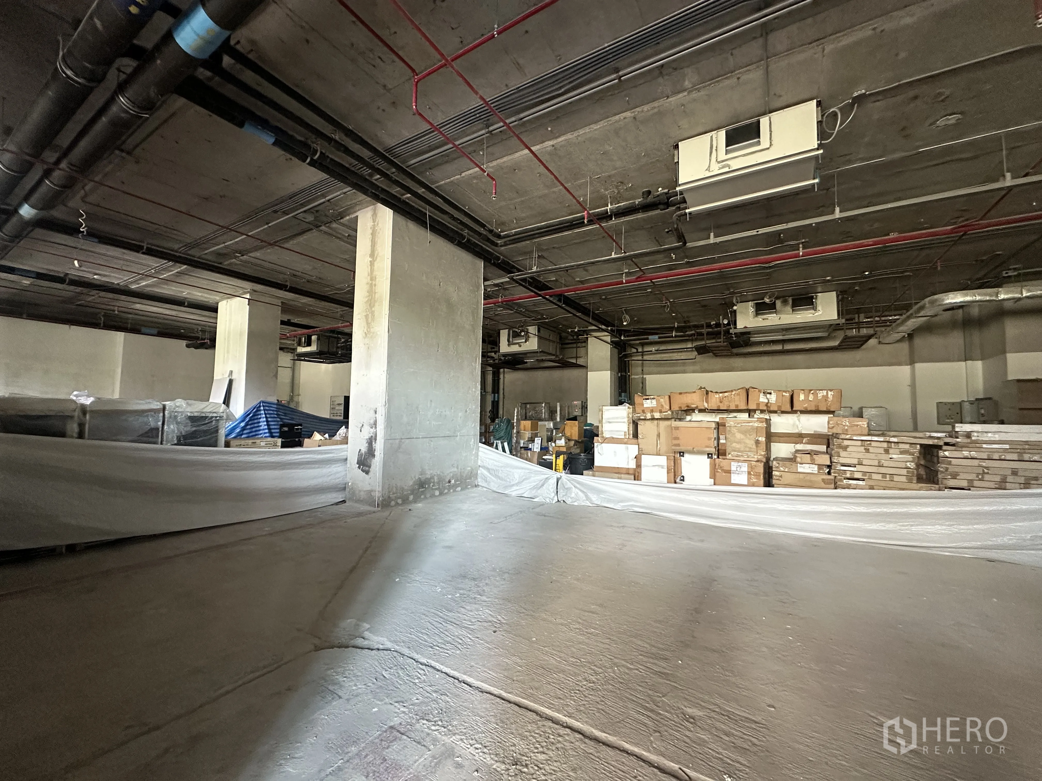 零售空间 for rent in Khlong Toei, Bangkok - 未完成的商铺内部，外露管线与成堆包装材料。