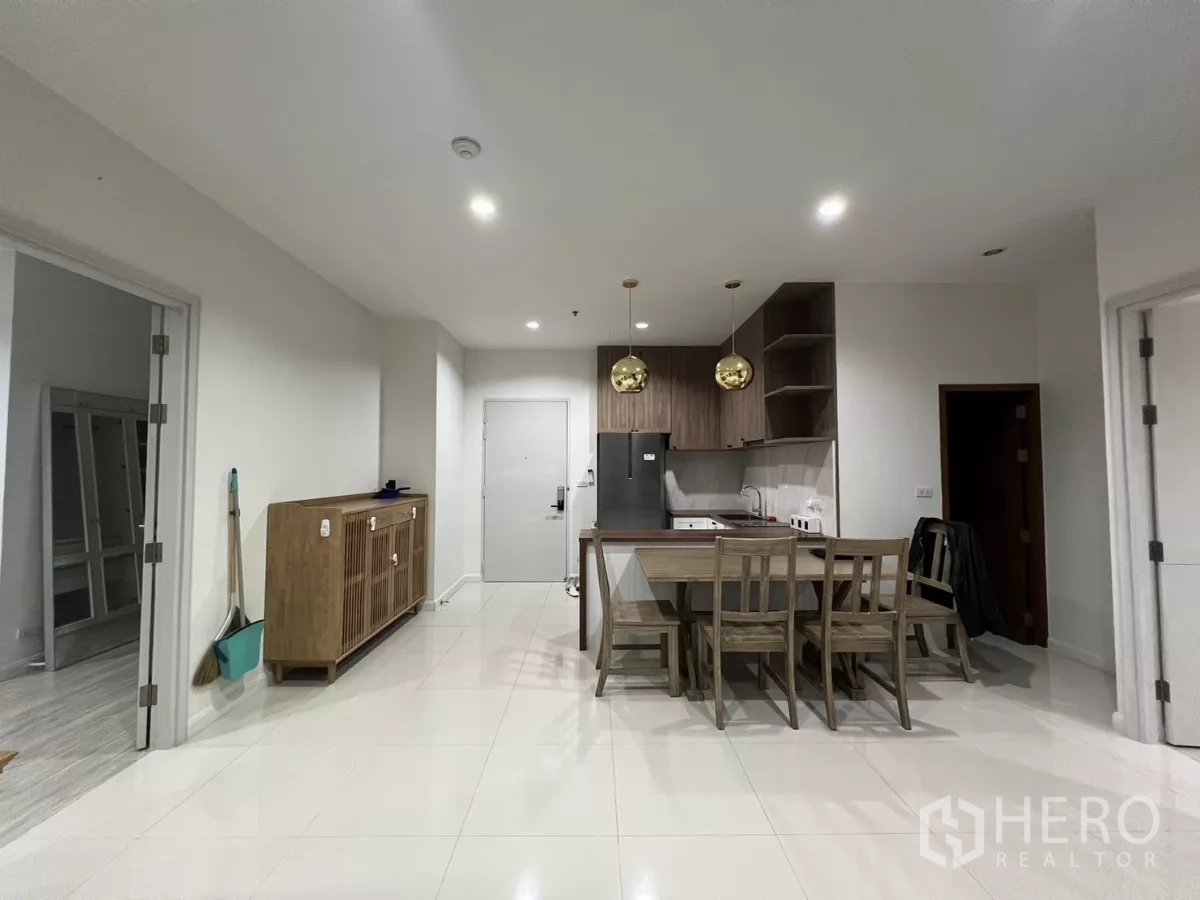 公寓 出租在Bang Kapi, Bangkok - 开放式餐厨区，木色橱柜与吊灯。