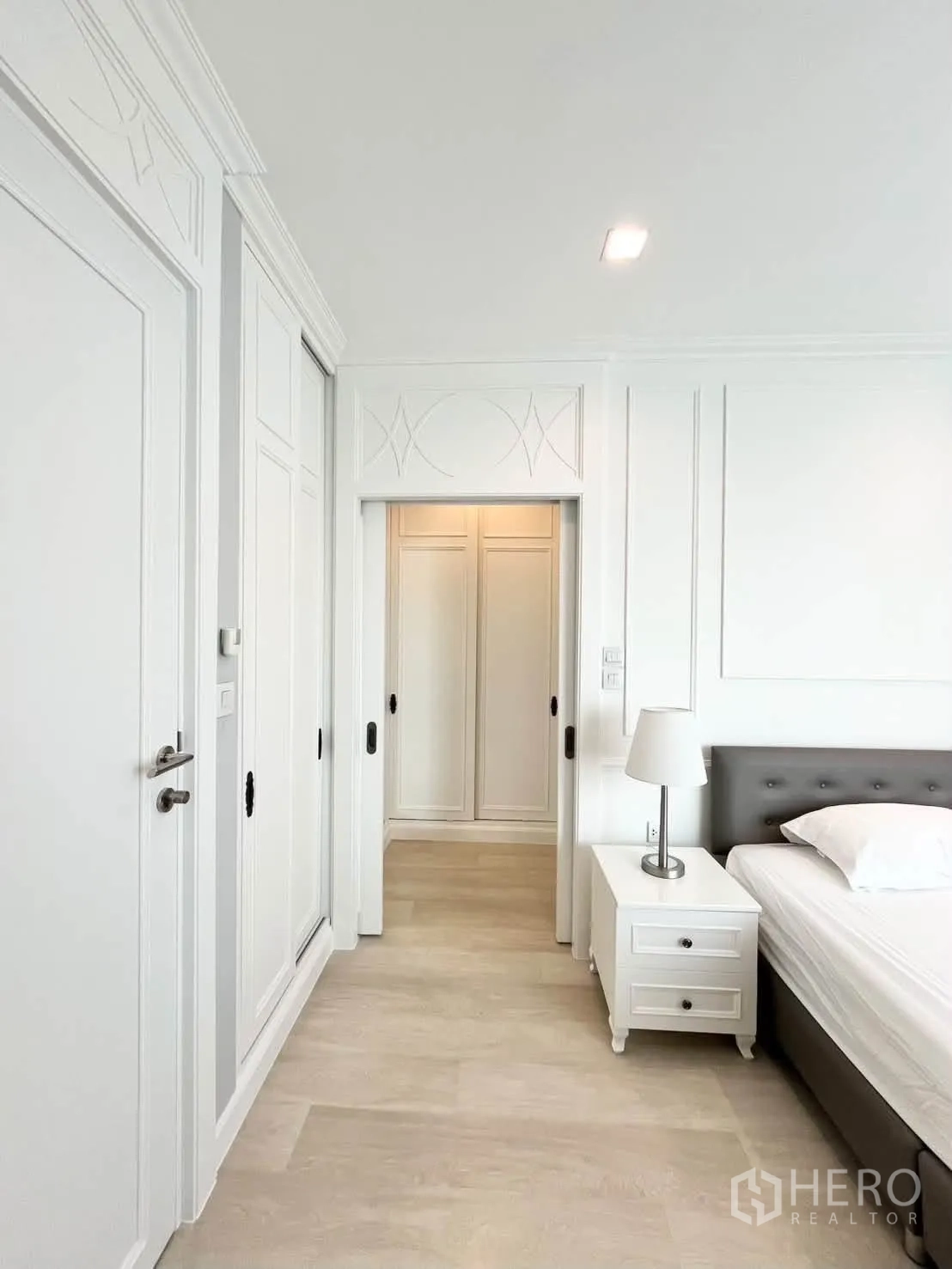 Condominium for rent in Pathum Wan, Bangkok - Bedroom hallway with multiple storage closets and a nightstand.