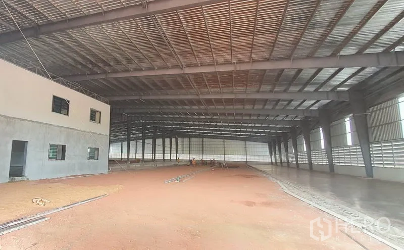 Warehouse for rent in Mueang Samut Sakhon, Samut Sakhon - Spacious warehouse interior with high steel frame, ventilated walls and a partially finished floor.