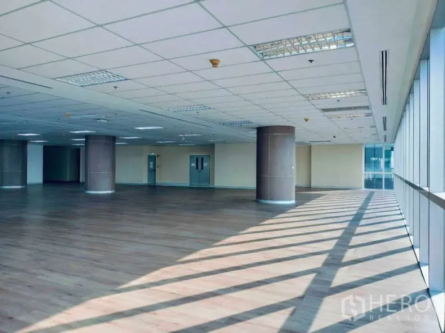 办公空间 出租在Sathon, Bangkok - 采光充足的开放式办公楼层，木质地板、圆形立柱与落地窗。