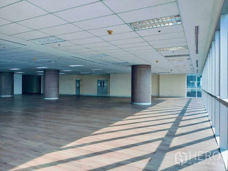 办公空间 出租在Sathon, Bangkok - 采光充足的开放式办公楼层，木质地板、圆形立柱与落地窗。
