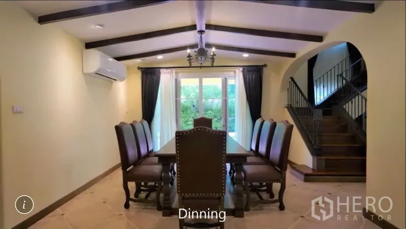 Detached House for rent or sale in Bang Phli, Samut Prakan - Formal dining room with long table, chandelier and garden views through sliding glass doors.