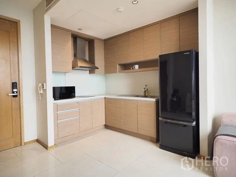 公寓 出租在Khlong Toei, Bangkok - 紧凑L形厨房，不锈钢油烟机与大冰箱