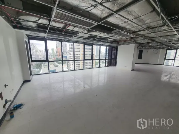 Office Space for rent in Bang Rak, Bangkok - Bright workspace with panoramic windows and structural column, ready for fit‑out.