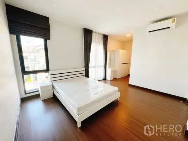 บ้าน ให้เช่าในBang Phli, Samut Prakan - ห้องนอนสว่าง เตียงคู่ พื้นไม้ หน้าต่างสูงพร้อมผ้าม่านและแอร์
