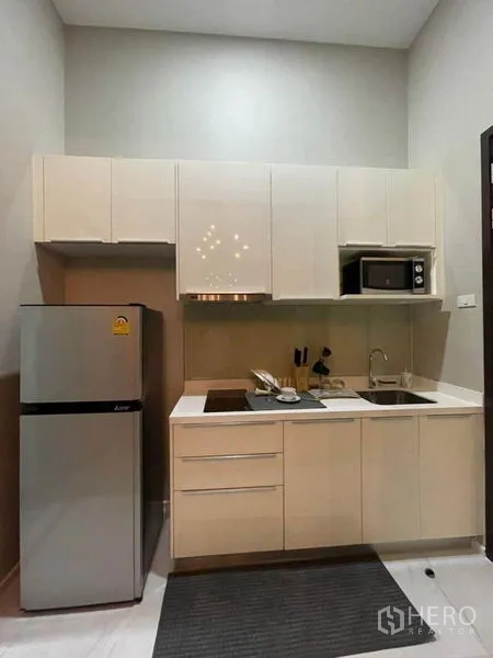 Condominium for rent in Ratchathewi, Bangkok - Full kitchenette with fridge, microwave, sink and ample storage cabinets.