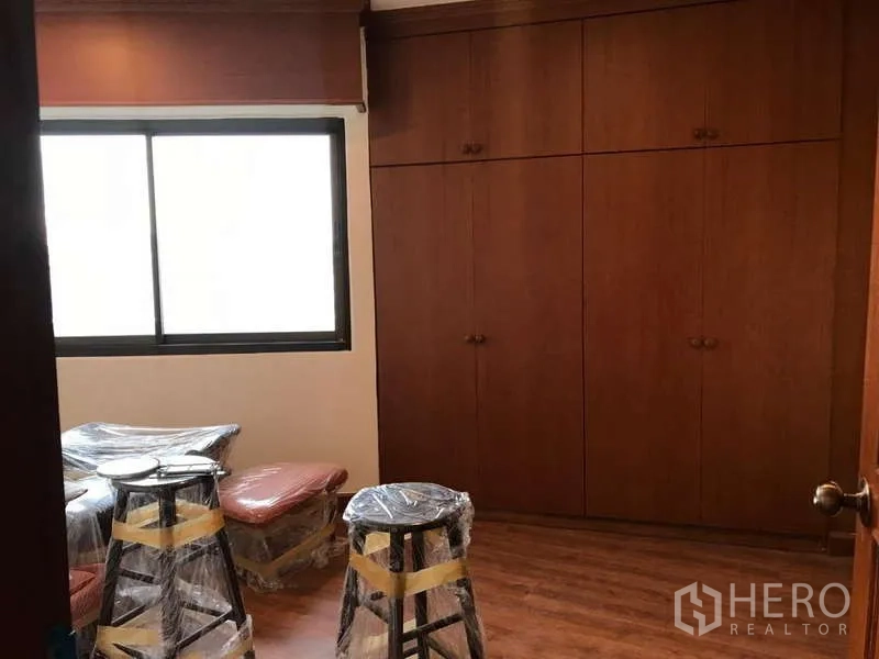 公寓 出售在Watthana, Bangkok - 卧室带大窗与整墙木质衣柜。