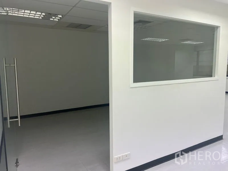 Office Space for rent in Watthana, Bangkok - Partitioned office area with an internal window and ceiling lights.