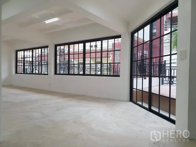 Home Office for rent or sale in Bang Na, Bangkok - Upper room with terrace access through black-framed glass doors.