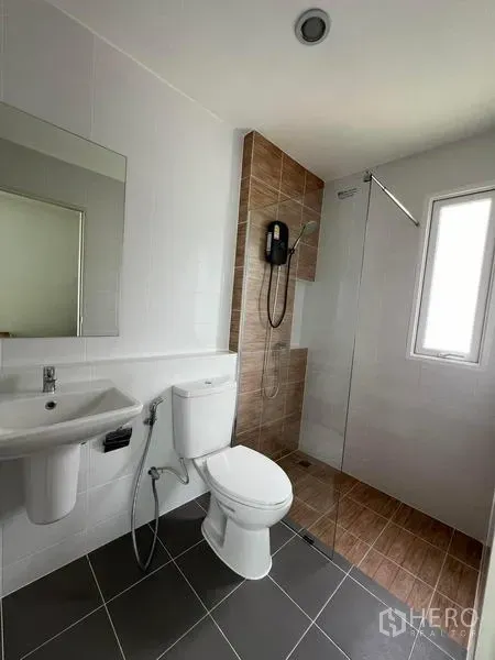 Detached House for rent in Bang Phli, Samut Prakan - Second bathroom featuring a glass shower screen, water heater, and tiled walls.