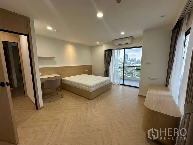 公寓 出租在Watthana, Bangkok - 大卧室配书桌、斗柜，滑门通阳台赏天际线