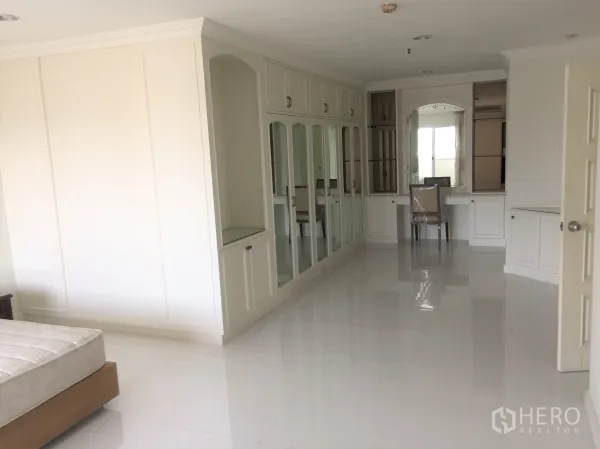 公寓 出租在Watthana, Bangkok - 主卧过道设大面积白色衣柜与梳妆台。
