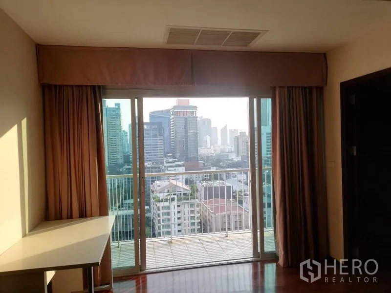 公寓 出租在Watthana, Bangkok - 推拉落地门通往阳台，可欣赏城市天际线景观。