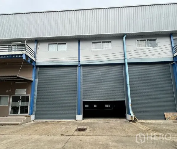 Warehouse for rent in Krathum Baen, Samut Sakhon - Warehouse facade in Om Noi with three large roller shutter doors and a wide loading apron.