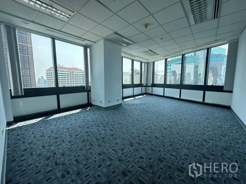 办公空间 出租在Khlong Toei, Bangkok - 转角办公室铺拼块地毯，环窗可览城市景观。