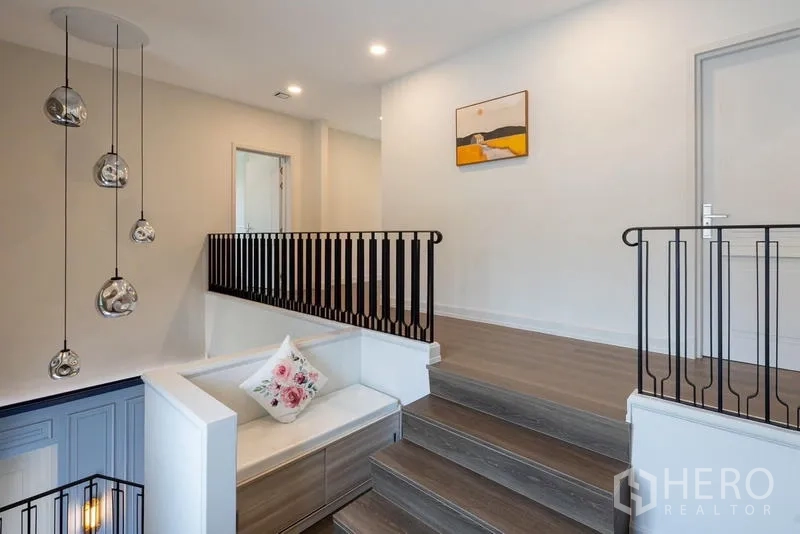 Detached House for sale in Saphan Sung, Bangkok - Upper landing with black railings and built-in bench seating.