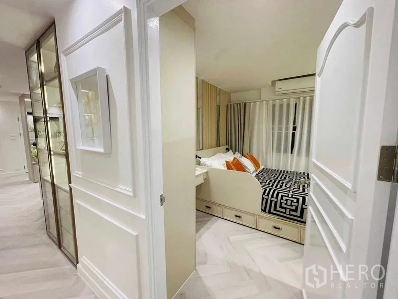 公寓 出售在Yan Nawa, Bangkok - 走廊望向卧室，床下抽屉收纳与玻璃展示柜。