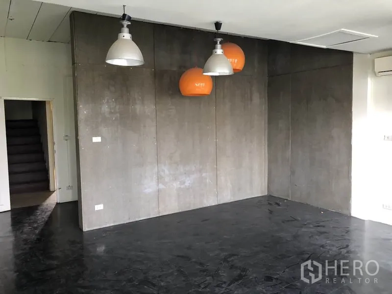 带办公室的家 出租或出售在Huai Khwang, Bangkok - 工业风房间，水泥质感墙板、吊灯与深色地面。