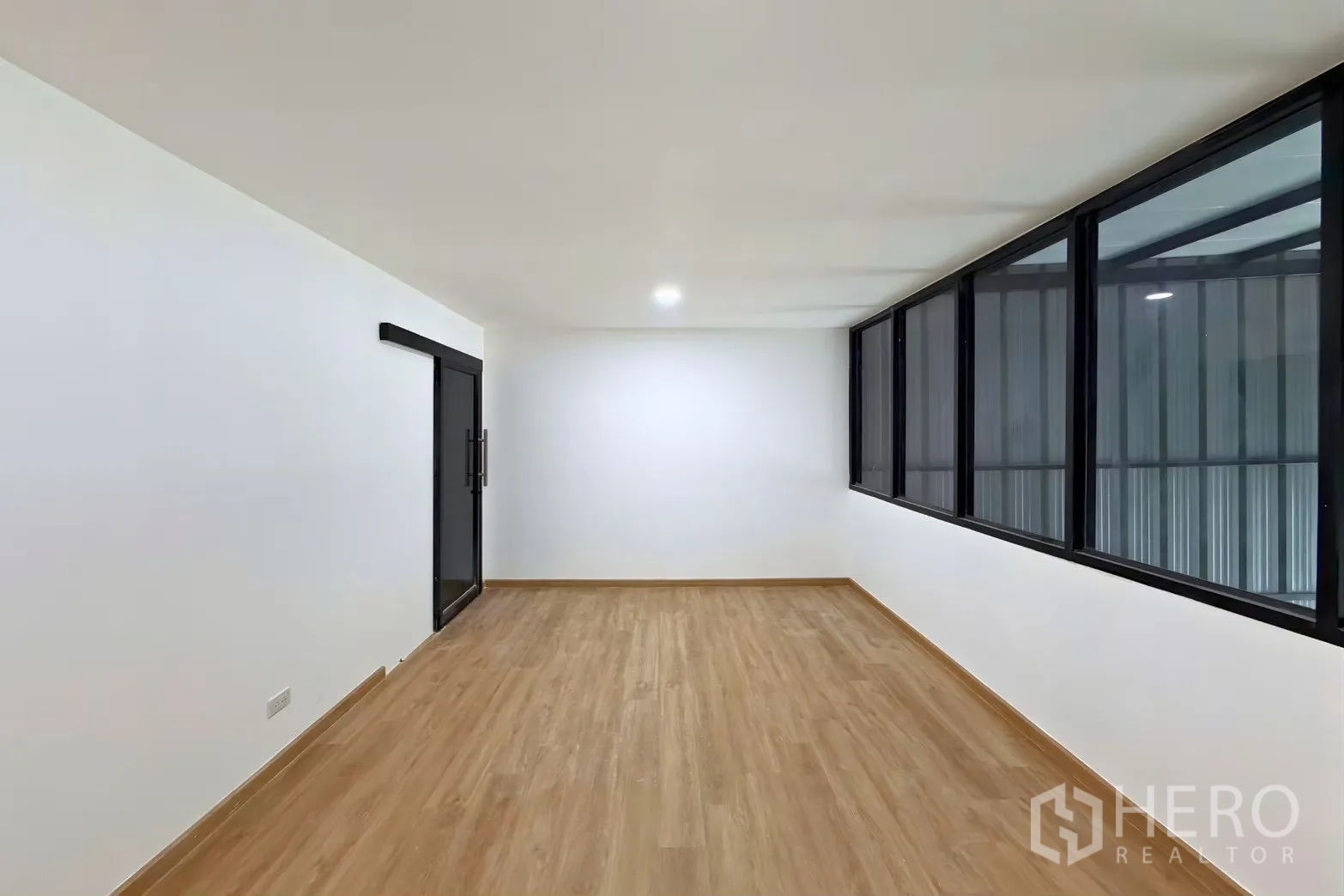 โกดัง for rent in Suan Luang, Bangkok - ห้องสำนักงานว่างพื้นลายไม้ ประตูบานเลื่อน และหน้าต่างภายในแนวยาว