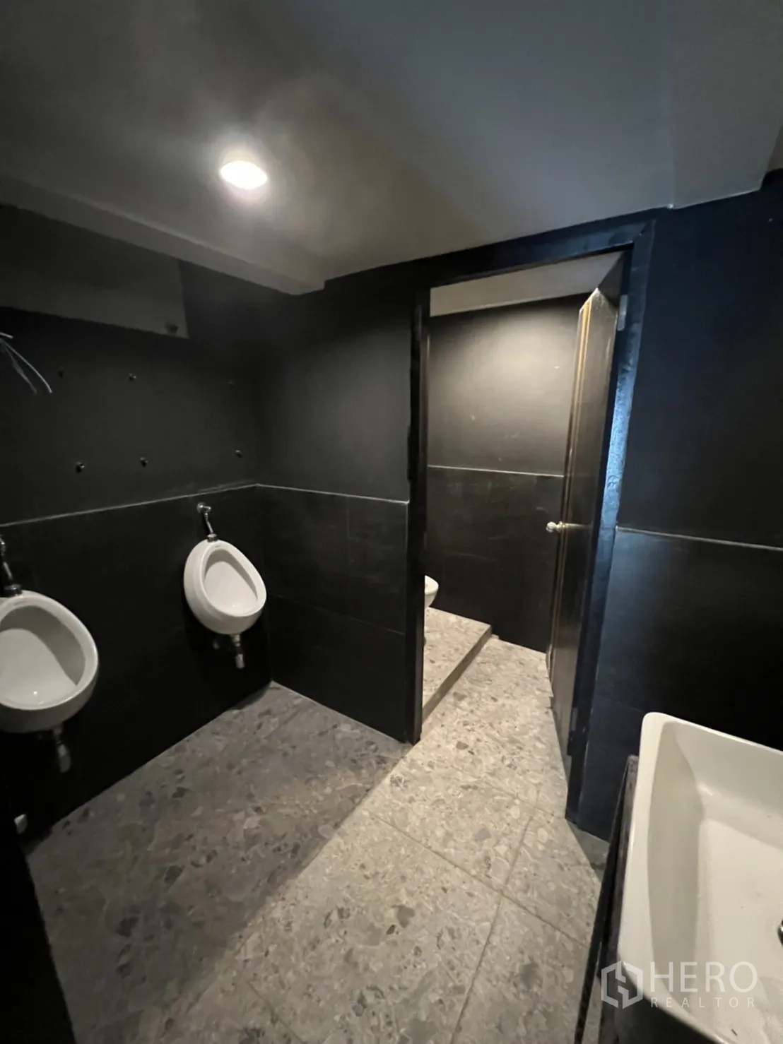 Home Office for rent or sale in Khlong Toei, Bangkok - Men’s restroom with urinals, sink and dark wall tiles.