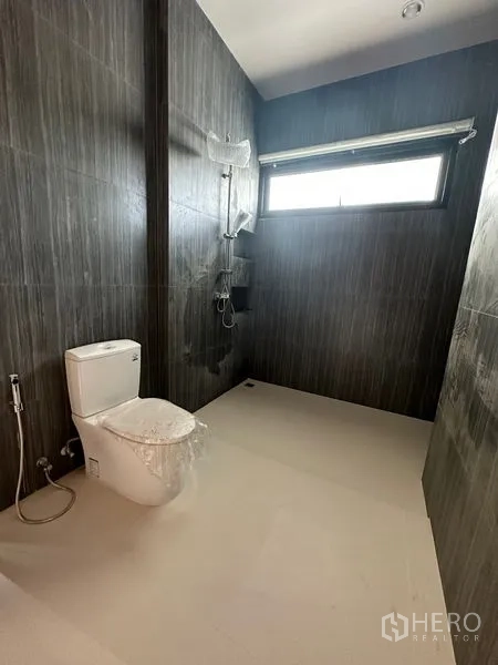 独立式住宅 出租在Watthana, Bangkok - 深色瓷砖浴室，步入式淋浴区与窗户，卫浴现代。