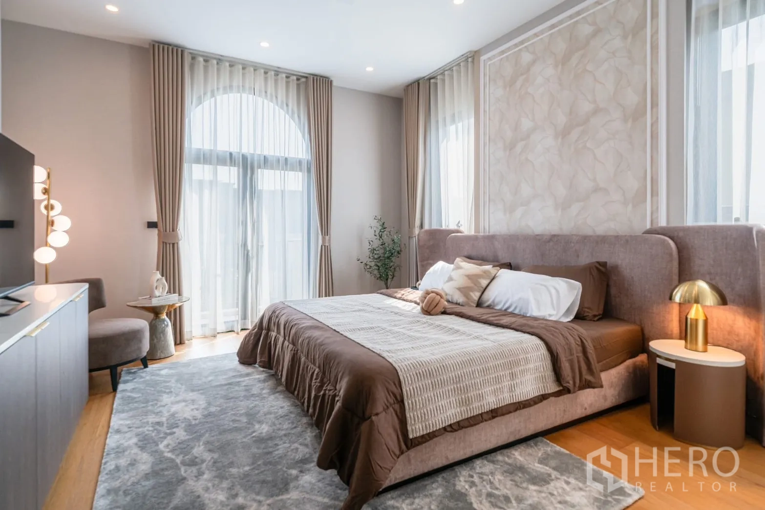 Detached House for rent or sale in Saphan Sung, Bangkok - Master bedroom with arched windows, sheer curtains and area rug.
