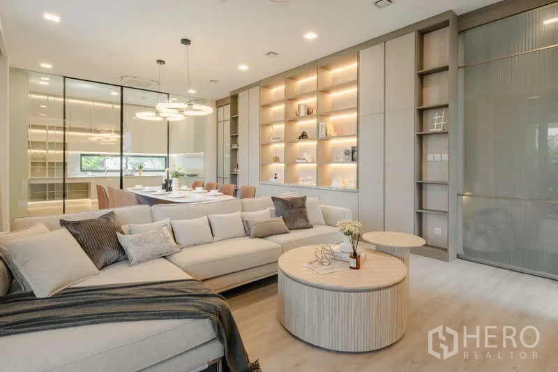 Detached House for rent in Saphan Sung, Bangkok - Spacious living-dining area with sectional sofa and illuminated display wall.