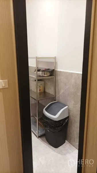 Retail Space for rent - Compact storage or pantry room with metal shelving and a waste bin.