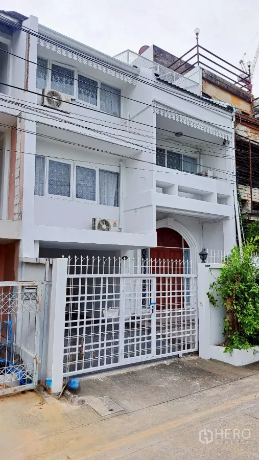 联排别墅 出租在Watthana, Bangkok - 旺那那区三层白色联排别墅外观，带大门与阳台。