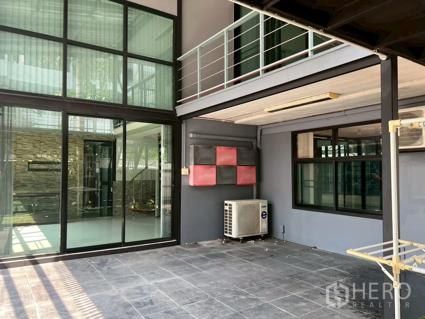 Detached House for rent or sale in Wang Thonglang, Bangkok - Covered outdoor area with sliding glass doors, AC unit and tiled flooring.