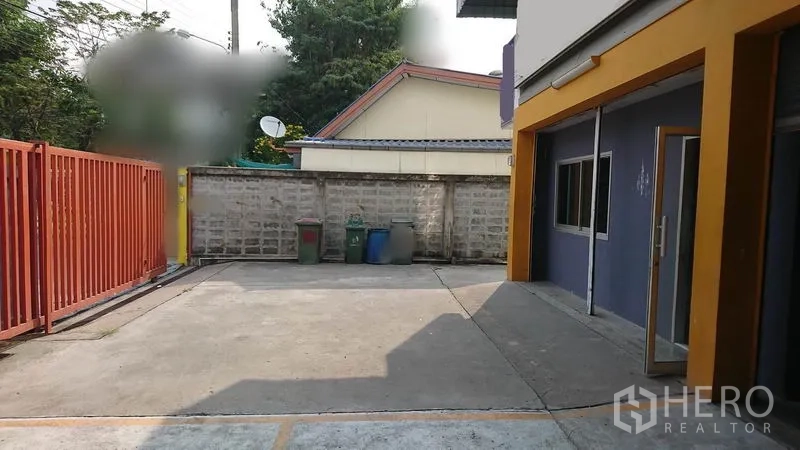Warehouse for rent in Lak Si, Bangkok - Gated concrete forecourt beside the warehouse, suitable for parking and truck maneuvering.