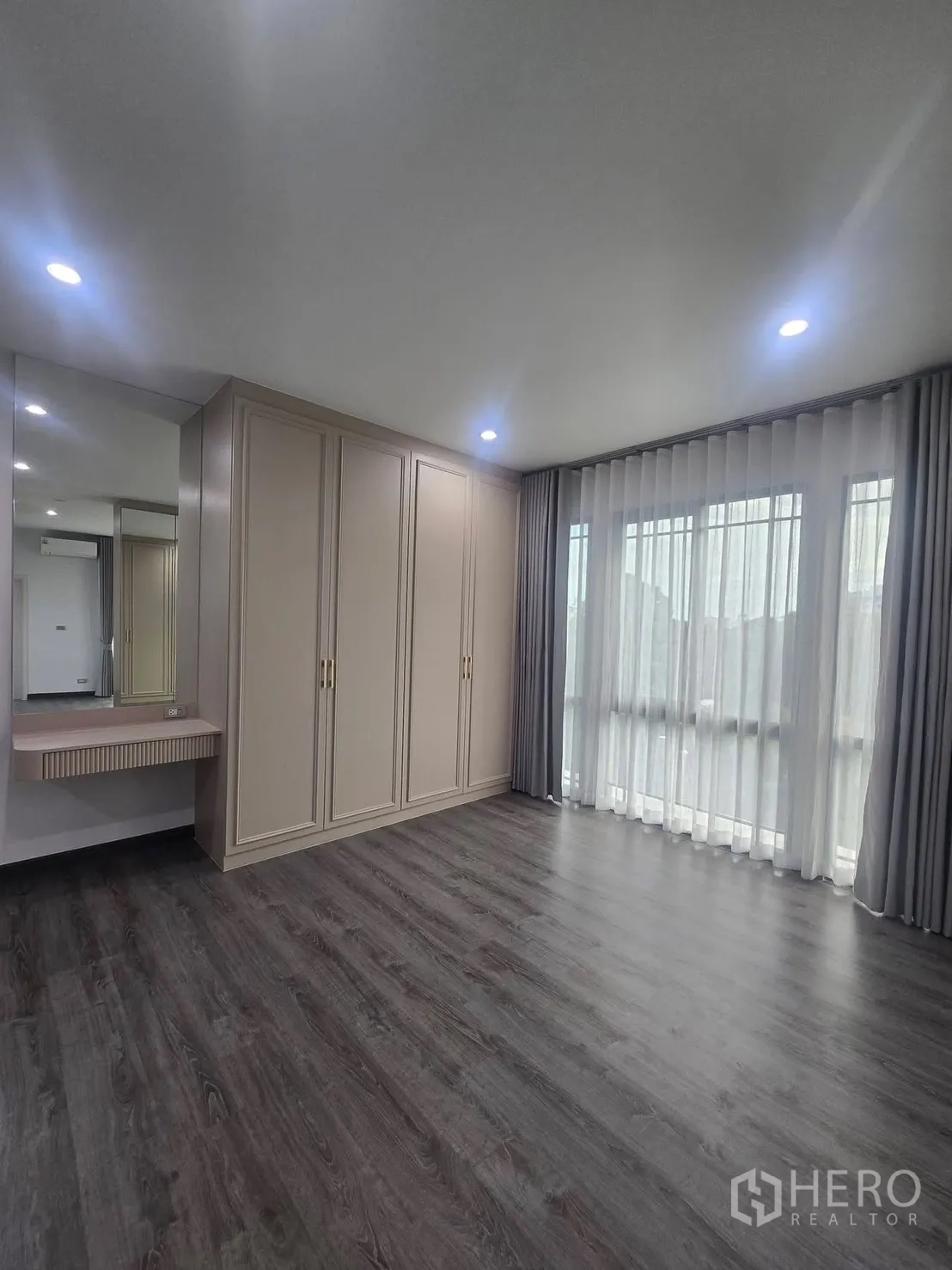 บ้านแฝด for rent in Suan Luang, Bangkok - มุมห้องนอนพร้อมตู้เสื้อผ้าบิวท์อิน โต๊ะเครื่องแป้ง และผ้าม่านโปร่ง.