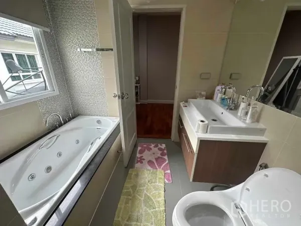 独立式住宅 出售在Saphan Sung, Bangkok - 现代浴室配按摩浴缸、台盆和采光窗。