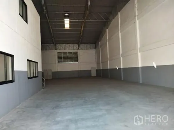 Factory for rent in Bang Phli, Samut Prakan - Spacious high-clearance factory interior with concrete floor, steel truss roof, and side windows in Bang Phli.