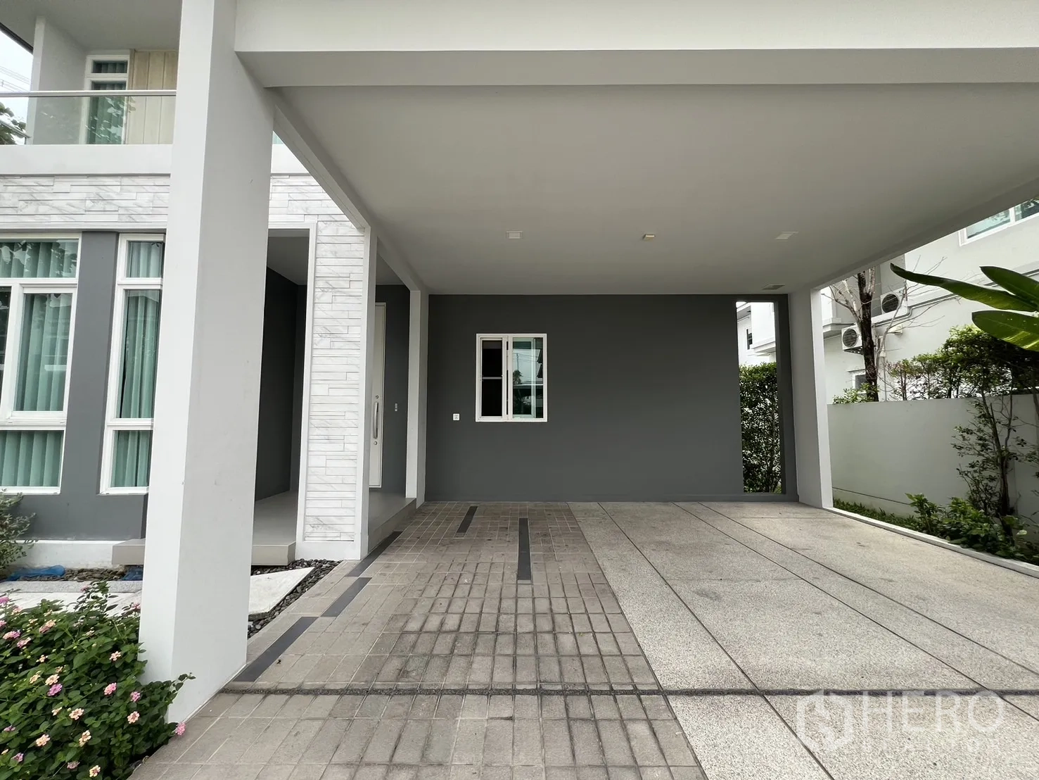 独立式住宅 出租在Prawet, Bangkok - 车棚与主入口特写，配高窗与立柱。